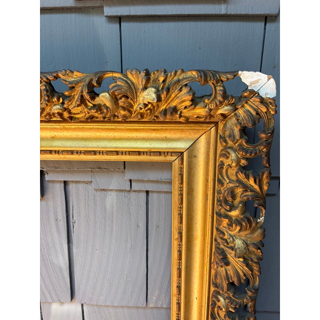 An extraordinary oversized antique Rococo Revival giltwood frame featuring lavish openwork foliate carving, scrolling...