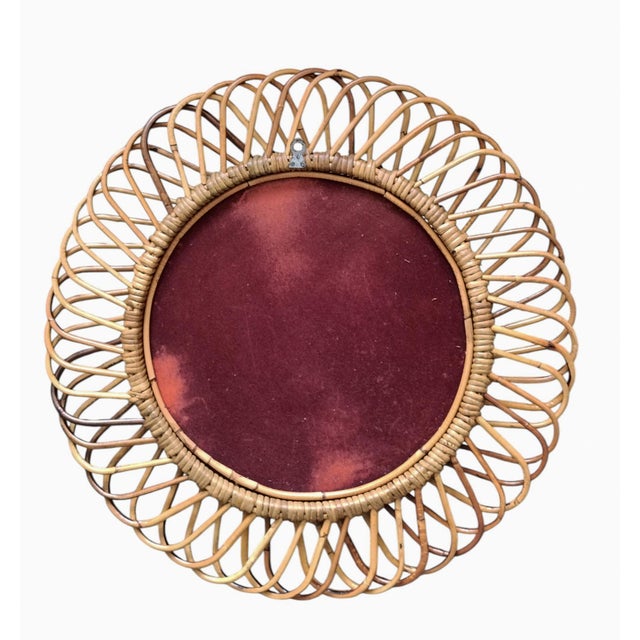 Italian rattan wall mirror (circa 1960s) by Franco Albini. The mirror has a complex weave of rattan in a series of...