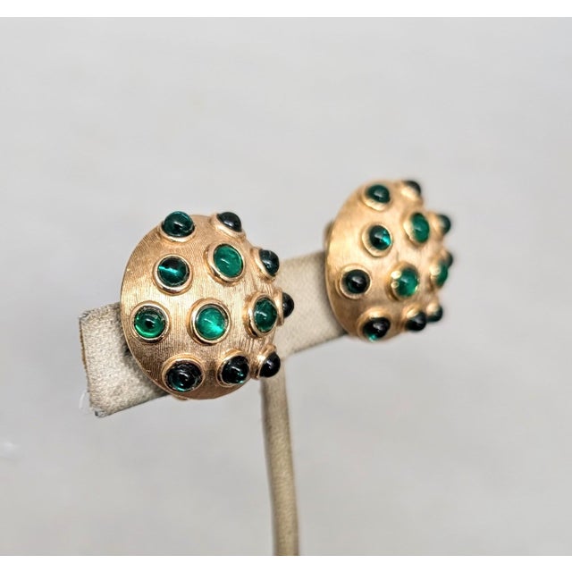 Hard to find 1960s round domed textured goldtone with three slightly bigger cabochon faux-emeralds in the middle and...