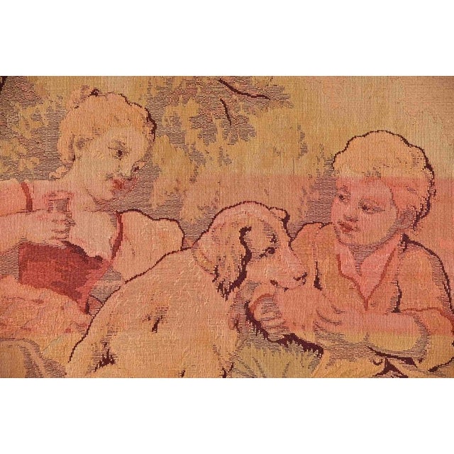 Bucolic scene is a vintage tapestry realized in 1950s in Italy. Children with dogs with floreal motifs on the sides. Bold...