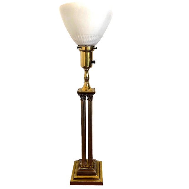 On offer is a pair of vintage Neoclassical-style lamps, each featuring brass columns topped by a torchiere (upward-facing)...