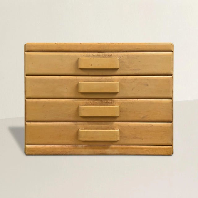 A chic early 20th century American modernist chest with four drawers with wide wooden pulls, and all with a beautiful...