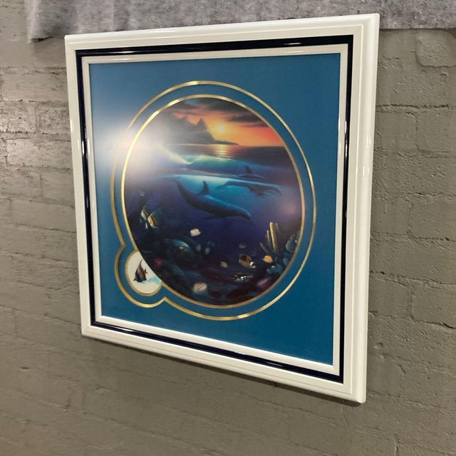 This vibrant framed print features a beautiful underwater scene with dolphins, tropical fish, and a stunning ocean sunset....