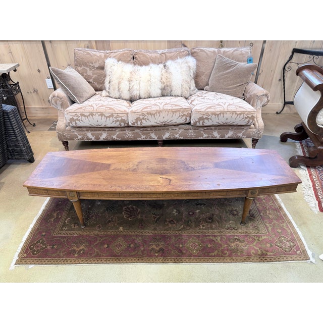 An exceptional vintage Mid Century Modern coffee table showcasing the refined artistry of finely matched walnut veneers...