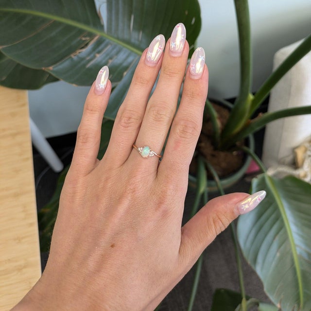A natural Ethiopian opal glows with rainbow play-of-color atop warm rose gold in this cabochon ring, finished with...