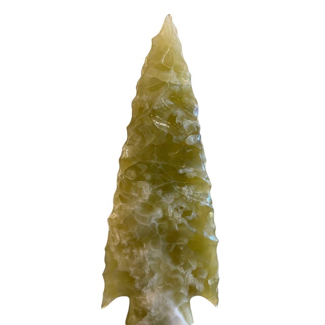 A dramatic late-20th-century decorative sculpture depicting an oversized arrowhead, hand-carved from richly translucent...
