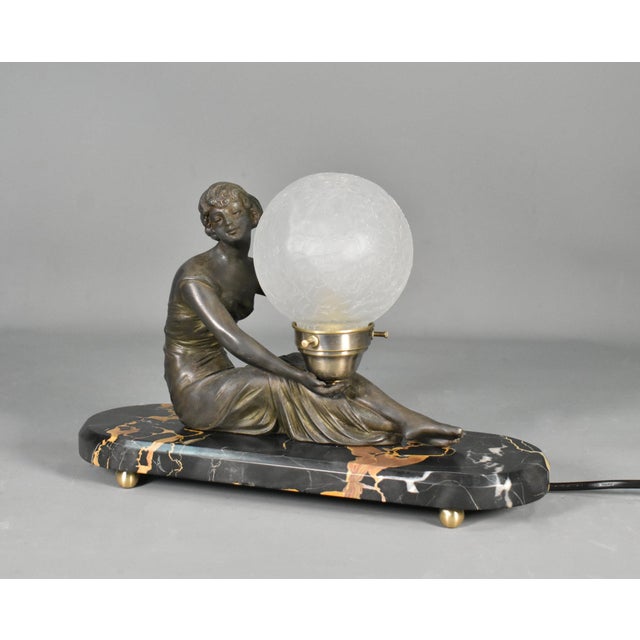 French Art Deco Lamp with Lady & Glass Globe Shade A charming example of early 20th-century French Art Deco lighting, this...