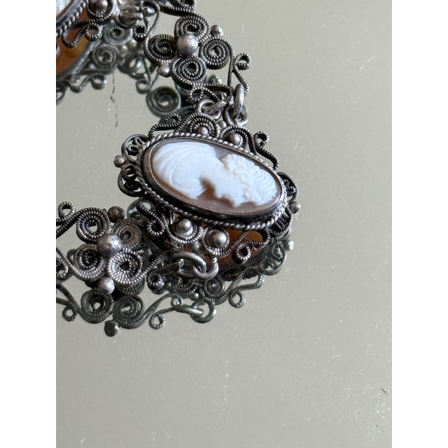 Vintage cameo filigree link bracelet featuring five oval carved cameo panels set within ornate silver-tone openwork...