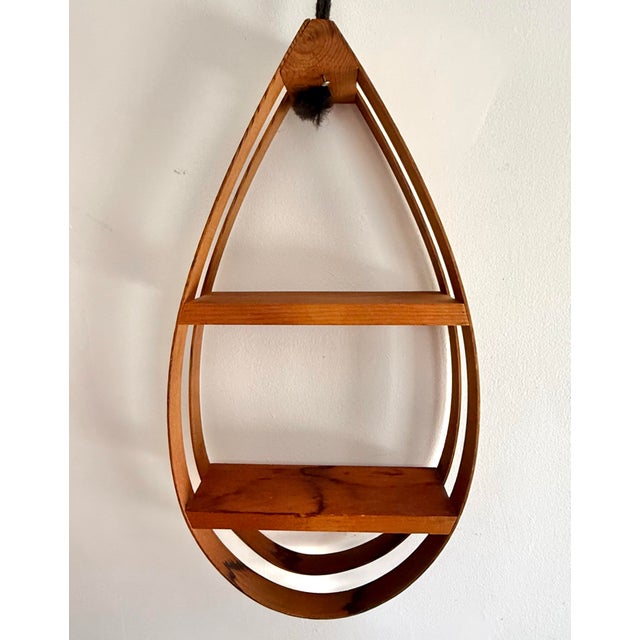 Beautiful midcentury Danish Modern bentwood hanging shelf with strips of teak in a teardrop shape holding two shelves of...