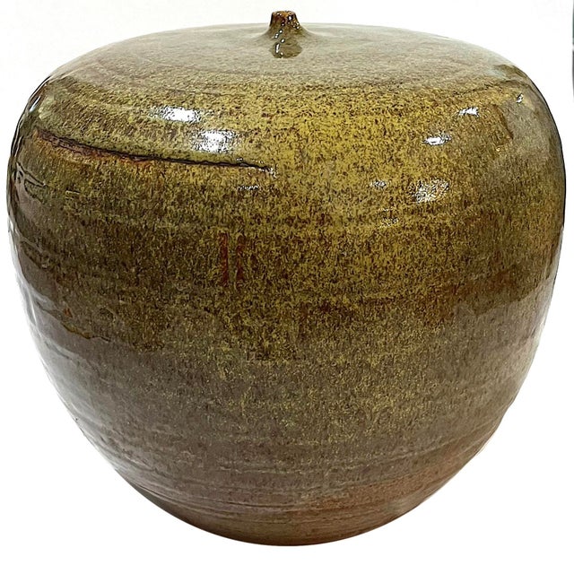 1980's hand-crafted studio pottery vessel toped by small "nipple" opening. .Shiny olive green glazed body. Measures 9"...
