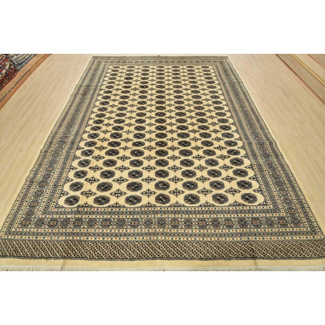 A tribal Bokhara rug hand-knotted with fine wool on a cotton foundation. This rug features rows of repeating medallions...