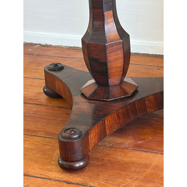 Antique Continental Art Deco carved and marquetry rosewood end table. This oval design is supported by a fluted and...