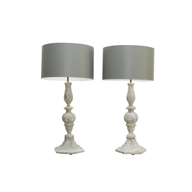 Oversized carved wooden finial lamps with classical decoration and grey drum shades. Painted to look like stone finials...
