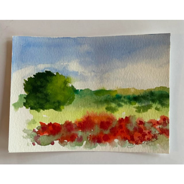 Colorful landscape featuring red flowers in the foreground. Signed and ready to frame.