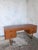 A distinctive mid-century teak desk with a floating twin-pedestal arrangement and sculptural sleigh-leg supports. Five...