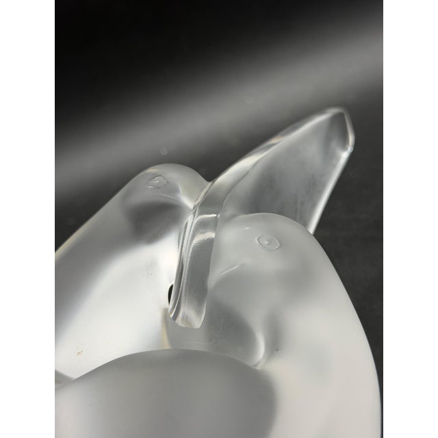 The Lalique Sylvie "Two Intertwined Doves" vase in clear and frosted crystal depicts two stylized, intertwined doves. The...