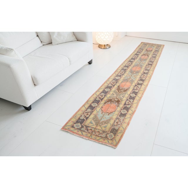 This is a vintage Turkish Oushak rug from the Mid 20th Century. The piece was hand-knotted.