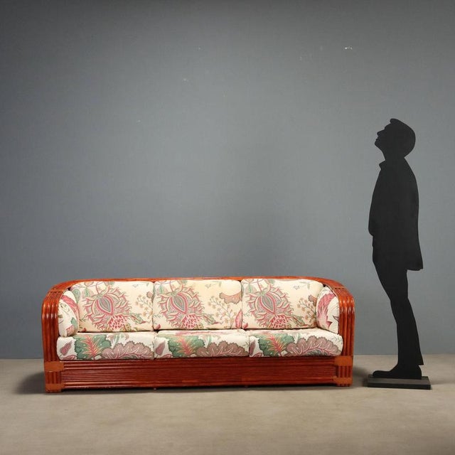 1980s sofa crafted by Maugrion, featuring a structure in rattan and red lacquered bamboo. Leather inserts add a touch of...