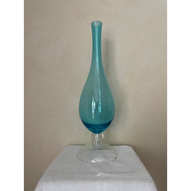 This tall aqua glass vase has a clear glass domed base. It is mid century in feel with cleaner lines. Elegant and sleek