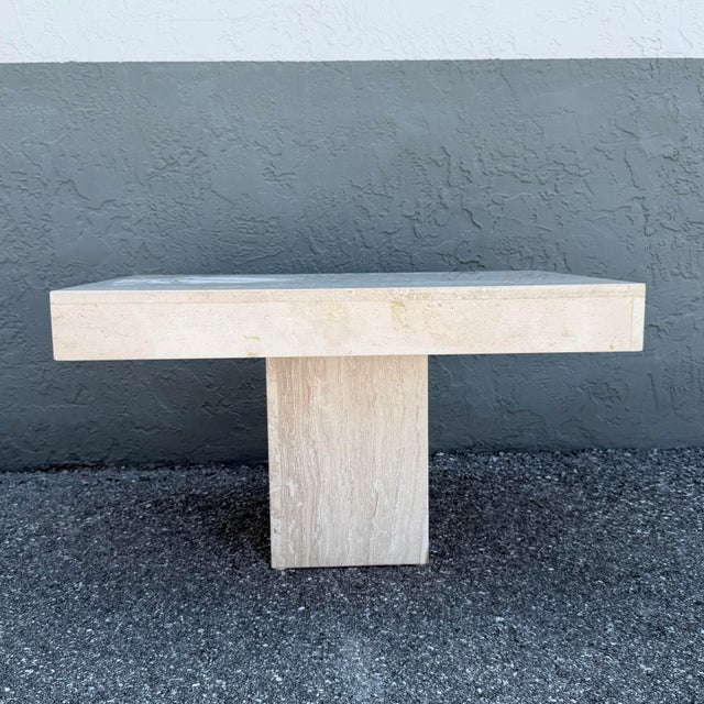 This striking vintage side table showcases the timeless elegance of solid polished travertine in a bold architectural...