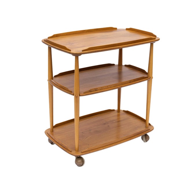 Mid-Century Modern ERCOL Elm and Beech Bar Trolley Designed by LUCIAN ERCOLANI, with three solid elm tiers with molded...