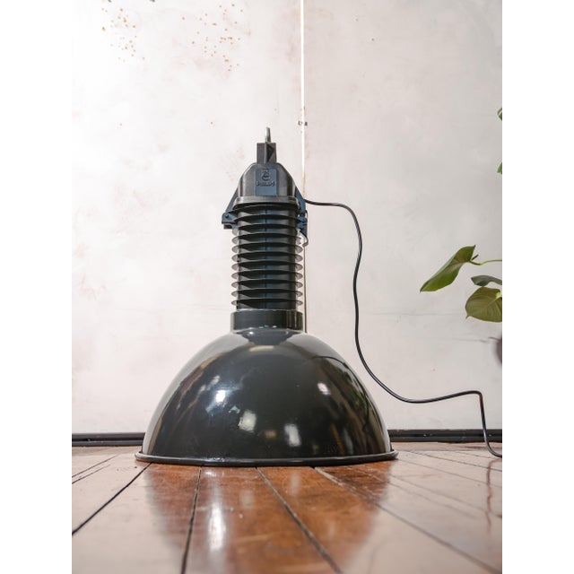 A 1950s philips hdk series factory pendant light in black enamel with a white interior, topped with cast aluminum, made in...