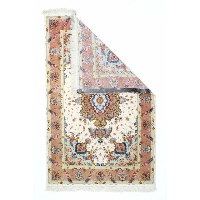 Silk warped and very finely knotted, this short pile city scatter features an eggshell field enclosing a pendanted and...