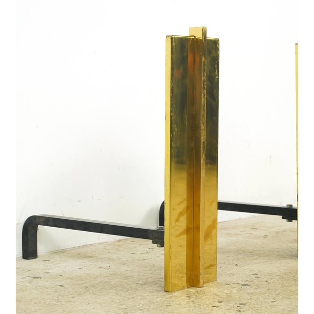 Mid Century style andirons made of tall brass rectangular panels with cast iron supports. Andirons, also known as...