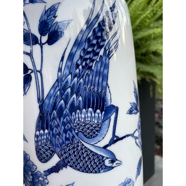 Vintage porcelain vase with blue peonies and a lovely bird design. Stands 14” tall. Numbered on bottom, maker unknown....