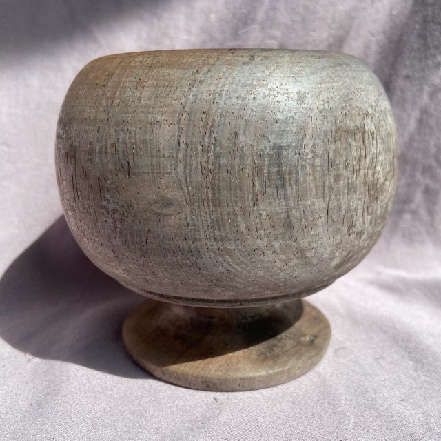 A handmade wooden bowl. The outside has a silver grey color and the inside is a rich warm brown.