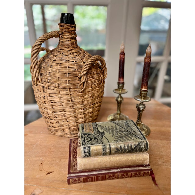 Imported from Germany. Antique hand blown glass demijohn bottle. Wicker wrapped with three handles. Great example of this...