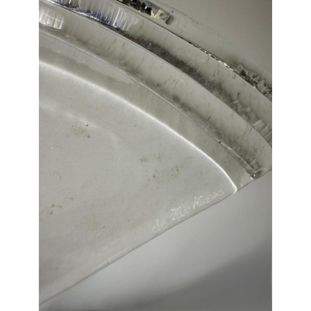 The elegant minimalism of the design is defined by a ribbed Murano glass shade—reminiscent of a fan or a hat—supported by...