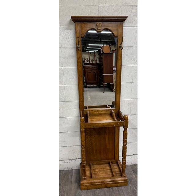 This is a beautiful vintage late 20th-century oak hall tree crafted in the Colonial Revival or Traditional style. Features...