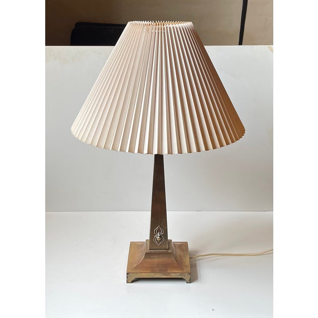 A tall stylish architecturally perceived table light featuring an obelisk rod/stem set with a black widow spider in silver...