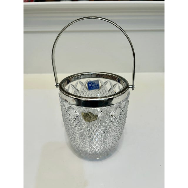 Offering a leaded glass bucket in a diamond pattern with a silver plated wide rim, handle and accompanying tongs. Made by...