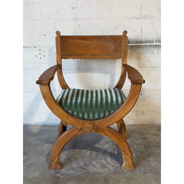 This "Kurul" armchair in style of Henning Kjærnulf features a dramatic curule X-frame construction and sculpted flat...