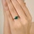 This elegant three-stone ring features a 1.85 carat oval-cut emerald and two oval-cut blue sapphires. The gemstones are...