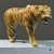 A vintage hand painted folk art sculpture of a snarling tiger. Construction: Body is wrapped in leather; hand painted with...