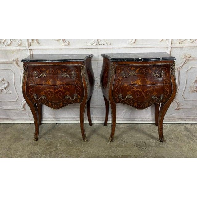 An enchanting and highly desirable pair of French Louis XV style bombé nightstands, or petite commodes, circa mid-20th...