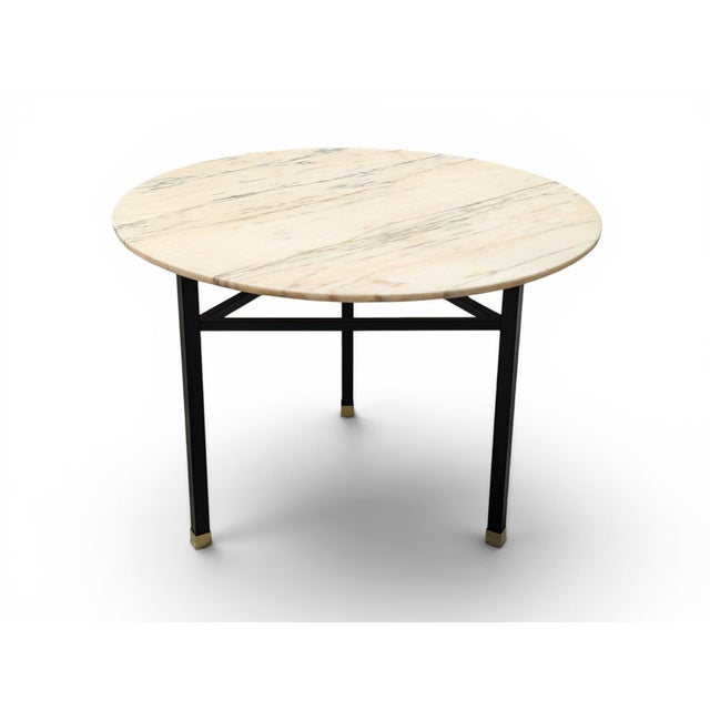 This refined round table stands out for its elegant veined marble top in warm beige and cream tones, characterized by...
