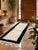 Boujad Runner Rug | Handwoven Berber Wool Runner with Ivory Field and Black Border This clean, minimal Boujad runner...