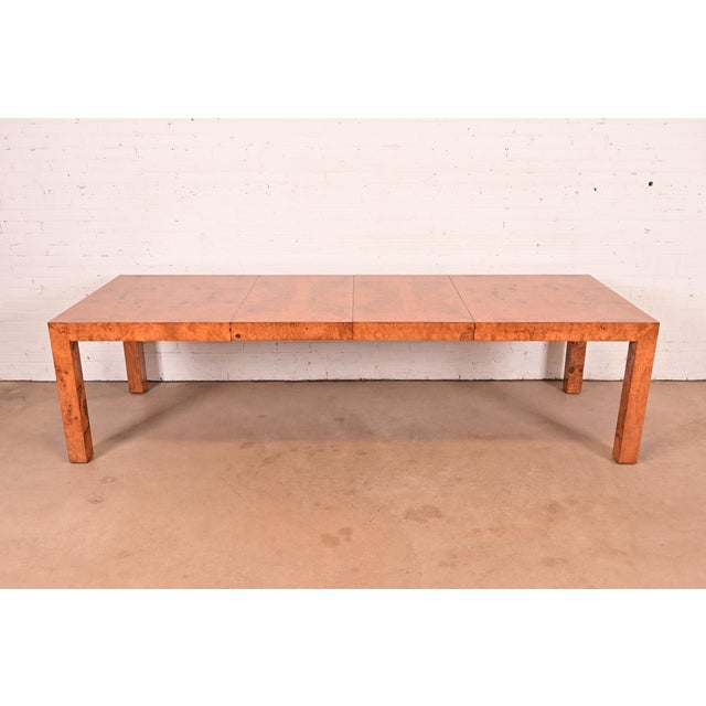 An exceptional Mid-Century Modern Parsons extension dining table in gorgeous book-matched burled olive wood By Milo...