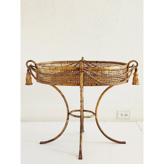 A very decorative Hollywood Regency style Italian gilt iron plant stand, featuring tassels and rope design. Perfect for...
