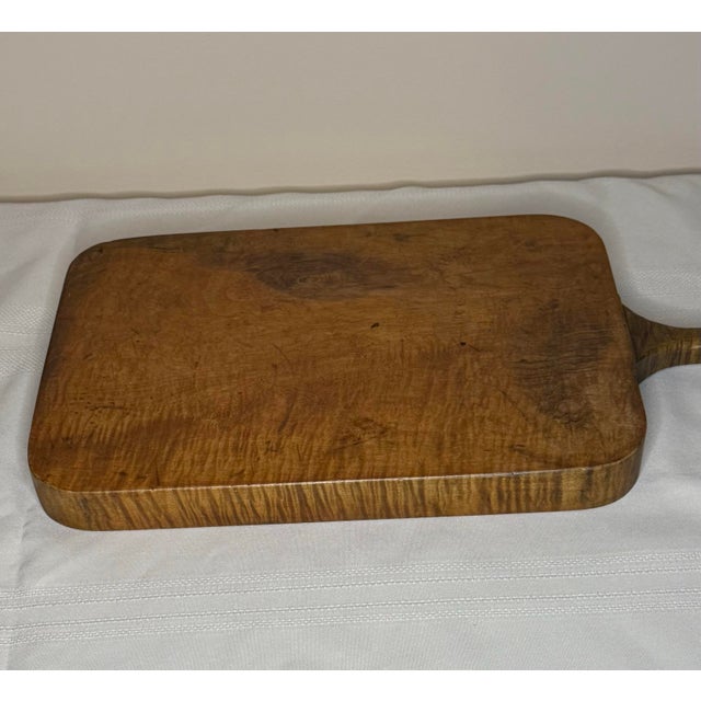 An exceptional and highly tactile antique American country farmhouse cutting board, carved from a single, substantial...