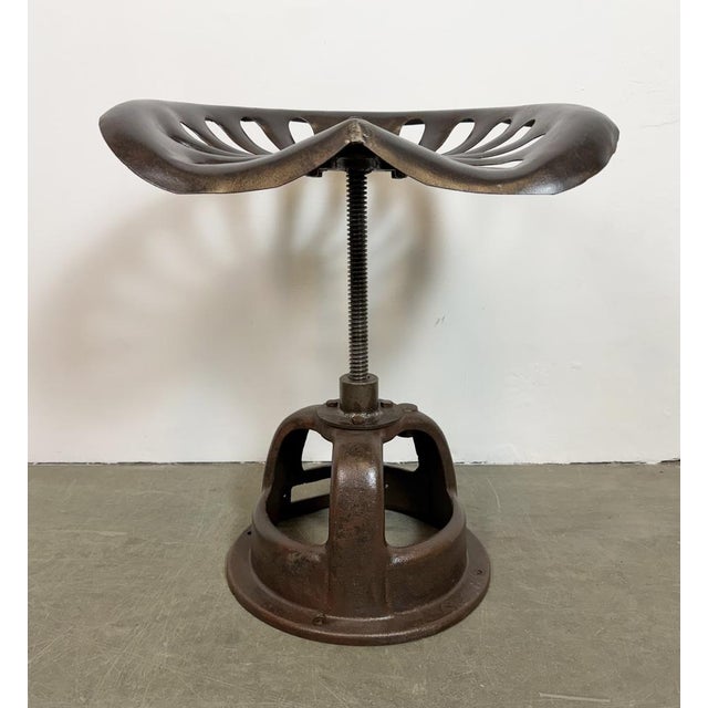 Vintage industrial height adjustable swivel chair from 1950s. An old tractor seat mounted on an iron construction....