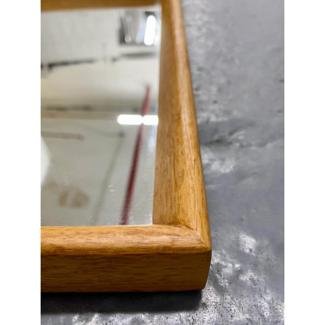 Oak Danish modern mirror, circa 1960's. Solid wood frame shows stunning grain and mirror features its’ original glass. The...