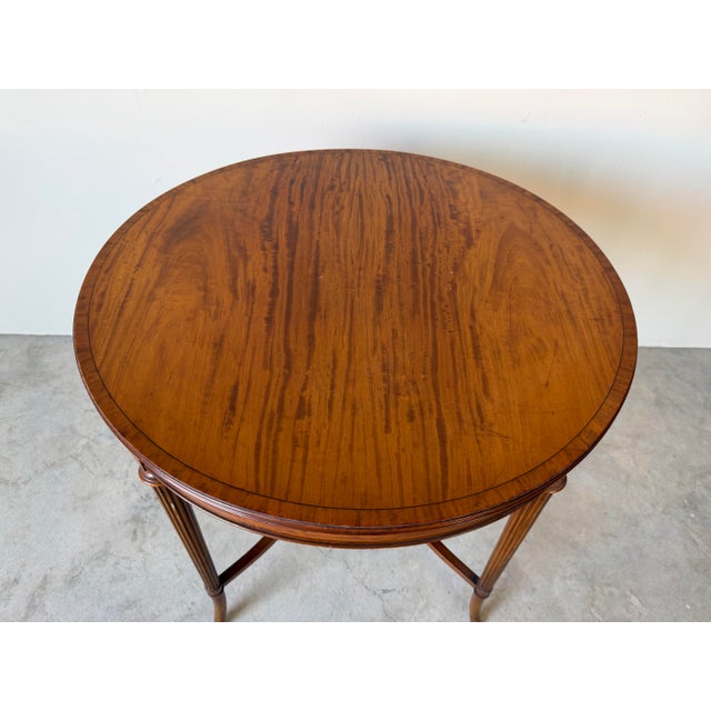 Elegant antique French round side table crafted from solid wood with a stunning flame mahogany top showcasing rich natural...