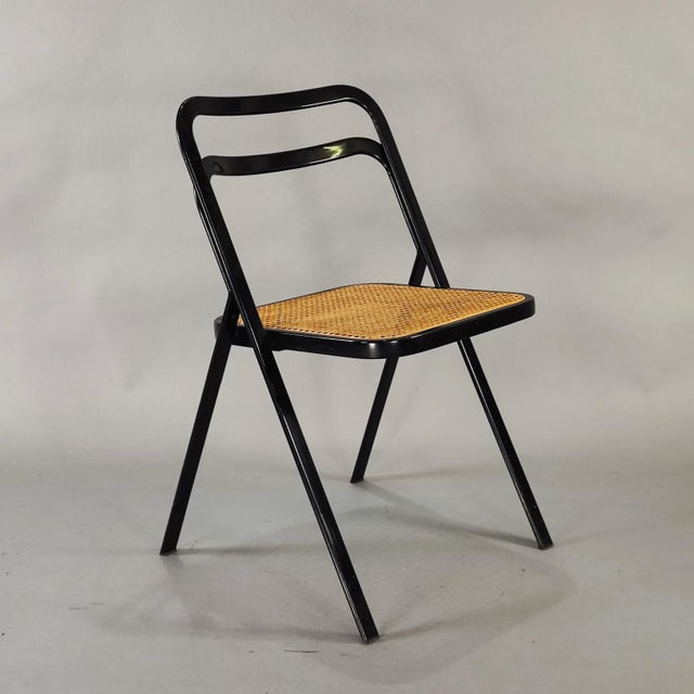 Set of 8 folding chairs by Giorgio Cattelan for Cidue, designed in the 1970s. Frame in black lacquered curved metal and...