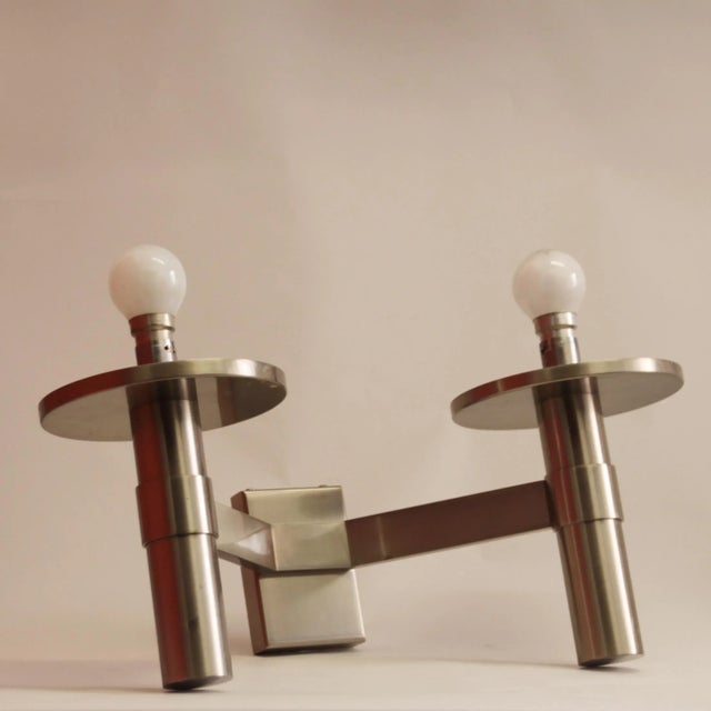 This wall lamp was designed and made in the 1940s by Jean Perzel. It features a two-arm metal frame with two round metal...