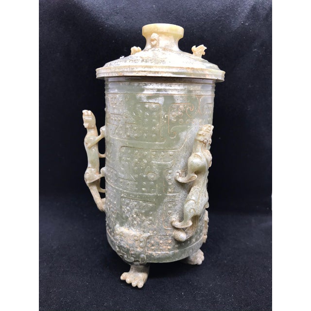 This is a finely carved nephrite jade covered vessel supported by three clawed feet fashioned in the Warring States style...